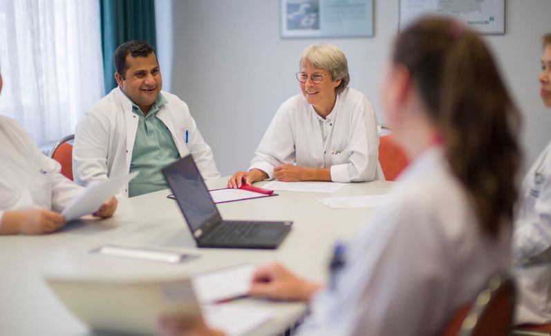 Ärzte besprechen Patientenakten in einer Konferenz
