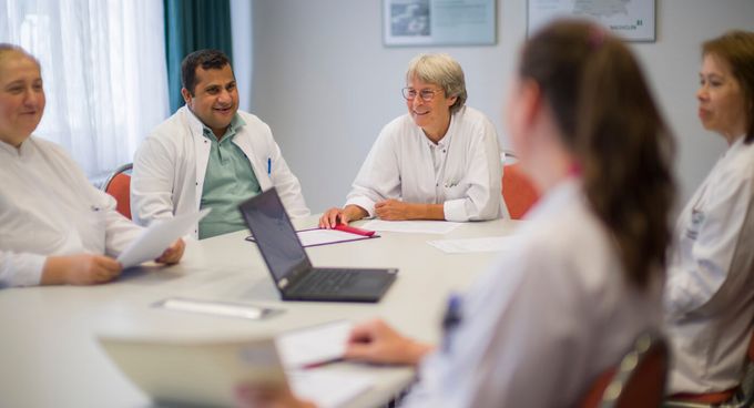 Ärzte besprechen Patientenakten in einer Konferenz