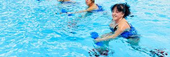 Patientin trainieren im Wasser mit kleinen Gewichten