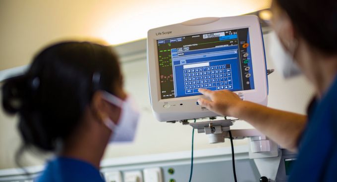 Pflegekräfte prüfen Vitalwerte auf dem Bildschirm