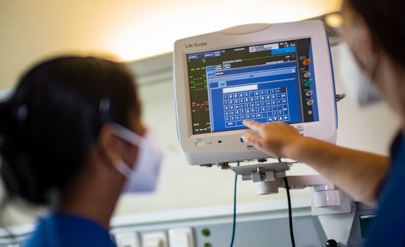 Pflegekräfte prüfen Vitalwerte auf dem Bildschirm