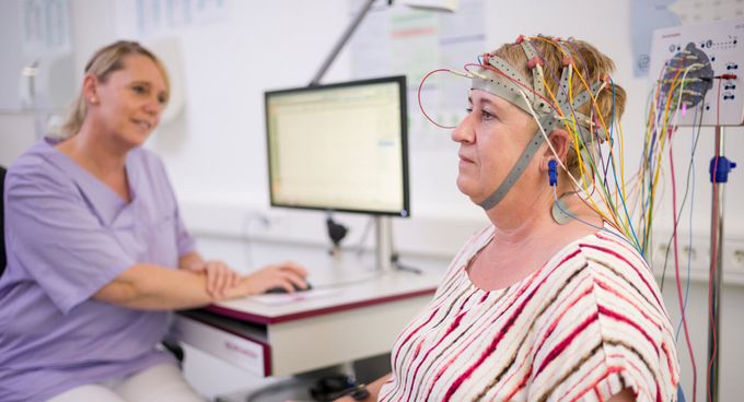 Pflegekraft beobachtet Patientin beim EEG
