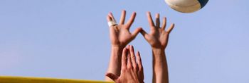 Hände und Volleyball beim Beachvolleyball